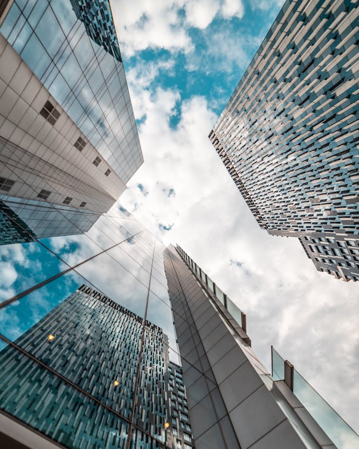 gallery-2 Low angle view of modern skyscrapers reflecting the cloudy sky in Brussels, Belgium.