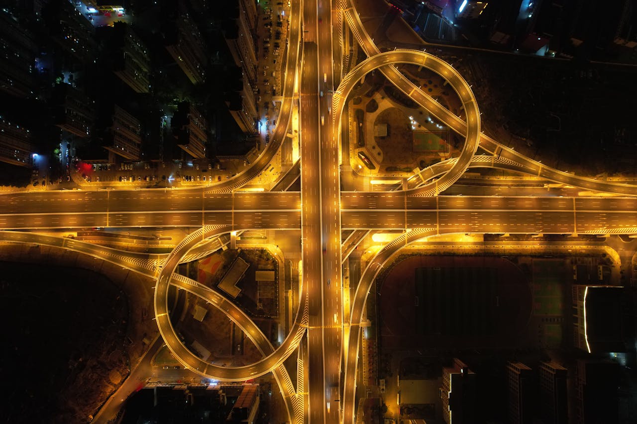 our-services-2 A stunning aerial view of a brightly lit highway interchange in China at nighttime, showcasing intricate patterns.